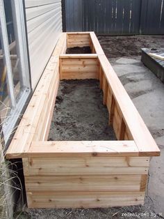 a wooden planter box sitting in the middle of a yard