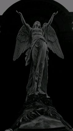 an angel statue on top of a building in black and white with light bulbs above it