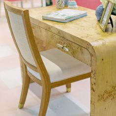 a wooden table with two chairs and a vase on top of it in a store