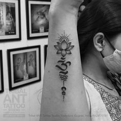 a woman wearing a face mask and holding up her arm with the word love tattooed on it