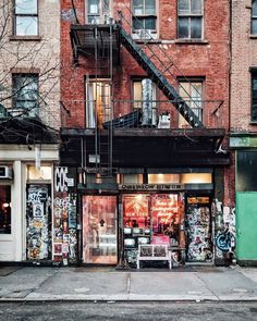 an old building with graffiti all over it's front and side windows, stairs leading up to the second floor