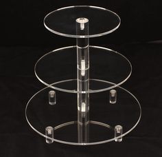 three tiered clear glass cake stand on black background