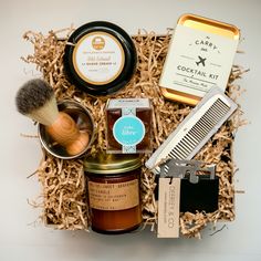 an assortment of grooming products in a box with shaving brush, comb and soap