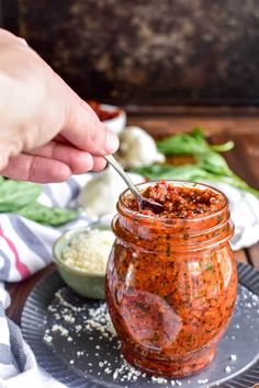 a person is spooning some food out of a jar