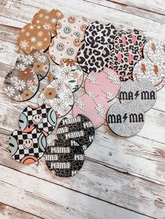 several different types of buttons on a white wooden surface with the word mama printed on them