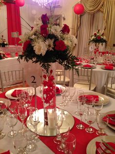 the table is set with red and white flowers