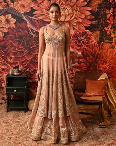 ‘Ethereal beauty’, is the word that comes instantly to mind while looking at this blush pink Anarkali. The Anarkali is a compilation of multi-generation vibes smoothly crafted in golden and silver embroidery work with floral motifs. Pair it up with some statement jewelry and watch everyone go gaga over your style. Sleeveless Anarkali kurta with dabka and nakshi embroidered yoke and hem SS zip closure in Anarkali and skirt Silver foil printed skirt with embroidery at the hem Floral embroidered pa Anarkali With Skirt, Lehanga Blouses, Floral Anarkali Dresses, Silver Embroidery Work, Foil Print Dress, Sleeveless Anarkali, Indian Dresses Anarkali, Salwar Kameez Wedding, Indian Fits