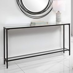 a black console table with a round mirror above it