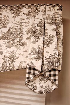 the curtains are lined up with black and white designs on them, along with a matching valance