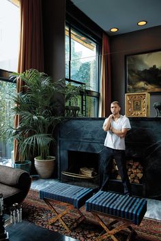 a man standing next to a fireplace in a living room