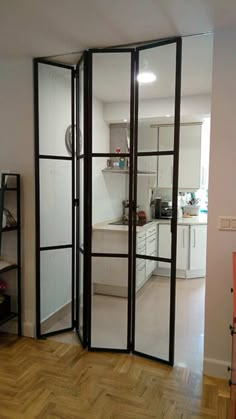 a room divider in the middle of a living room with wood flooring and white walls