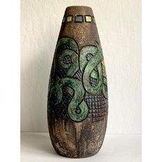 a decorative vase with an octopus painted on it's side, sitting against a white wall