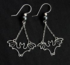 "Spookily cute bat earrings are handcrafted from silver filled wire, carefully wrapped into the shape of your favorite flying mammal! Metal has been antiqued then polished, for a lovely contrasting finish. \"Bats\" measure approximately 1.25 inches from wingtip to wingtip, and hang from comfortable French hook ear wires. Total earring length from top of ear wire to bottom of bat dangle is approximately 2.25 inches. *Silver filled wire meets the same legal requirement of \"gold filled\" as it is Bat Wire Wrap, Earing Inspiration, Rings Video, Bead Bugs, Wire Shapes, Wounded Healer, Bat Jewelry, Kitchen Witchery, Bat Earrings