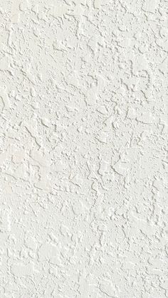 a white stucco wall with small cracks in the middle and some paint chipping on it