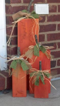 three pumpkins with burlocks tied to them sitting in front of a brick wall