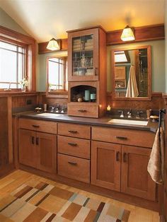 a bathroom with wooden cabinets and two sinks