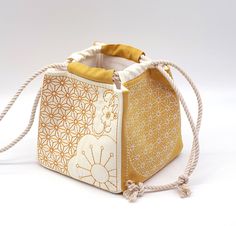 This bag was sewn in the Japanese style of the Komebukuro Style and quilted with elegant sashiko embroidery. On the surface is sakura and butterfly embroidery. In the past Komebukuro bags were used in Japan to store rice, so it sits on the ground nicely and has a pretty shape when filled. You can use it as a storage bag for knitting utensils, cosmetics, grain and all sorts of other things, or as a bag to transport your wallet or lunch box. Whether it is used as a home accessoire or for transport Sakura Embroidery, Embroidery Quilt, Sac Tote Bag, Bento Bag, Japanese Knot Bag, Japanese Bag, Bento Bags, Rice Bags, Sashiko Embroidery