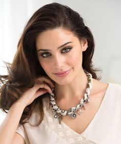 a beautiful woman wearing a necklace with pearls