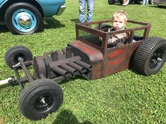 a young boy sitting in a homemade race car