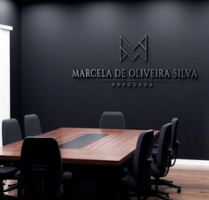 an empty conference room with black chairs and a wooden table in front of the wall