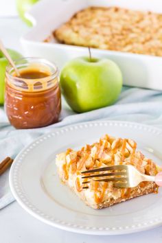 an apple pie is on a white plate with a fork in it and some apples next to it