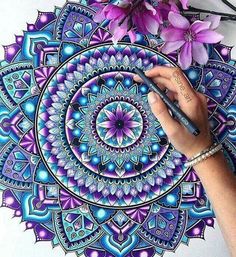 a person drawing on paper with purple flowers