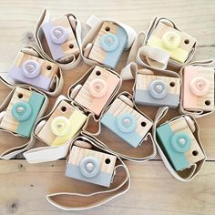 several small cameras sitting on top of a wooden table next to a string and paper bag