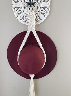 a hat hanging from the side of a wall with a crochet design on it