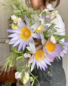 a woman holding a bouquet of flowers in her hands