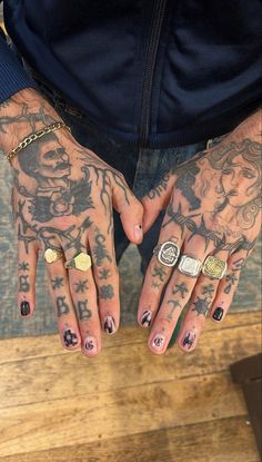 tattooed hands with rings and tattoos on them