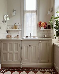 a kitchen with a sink, window and rug in the floored area next to it