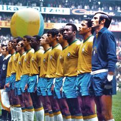 a group of men standing next to each other in front of a ball on top of a field