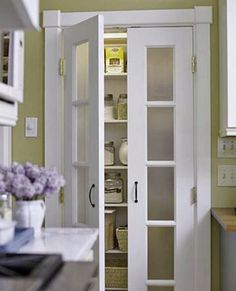 an open pantry door in the middle of a kitchen