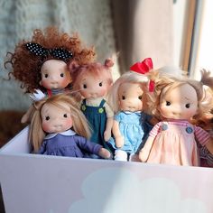 a group of dolls are sitting in a box