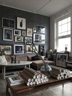 a living room filled with furniture and framed pictures on the wall above it's coffee table