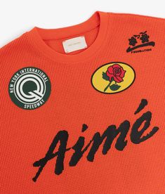 an orange jersey with black lettering on the chest and two red roses in the center