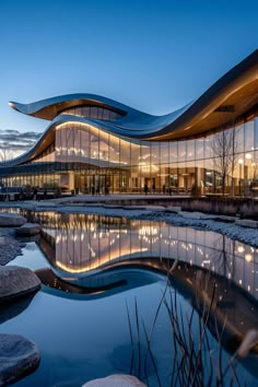 a large building that is next to a body of water with lights on the side