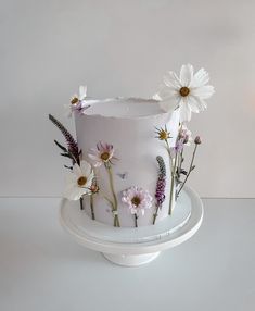 a white cake with daisies and lavenders on top