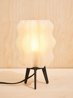 a lamp that is sitting on top of a wooden table next to a wood paneled wall