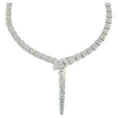 From the renowned Bvlgari of Italy, emerges a masterpiece from their Serpenti collection – an exquisite necklace meticulously crafted in 18-karat white gold. Prepare to envelop yourself in the radiant embrace of 14.74 carats of round brilliant-cut diamonds, each gleaming with an impeccable F color and VVS-VS clarity. This necklace, measuring a graceful 15.3 inches in length, arrives with its original box and authentic Bvlgari paperwork, ensuring its pedigree and prestige. For over seven decades, Serpent Necklace Bulgari, Bvlgari Jewelry Necklaces, Bvlgari Necklace, Bvlgari Jewelry, Bvlgari Serpenti, White Gold Necklaces, Elizabeth Taylor, Drop Necklace, The Prestige