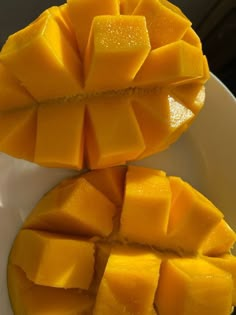 two pieces of mango sitting on top of a white plate