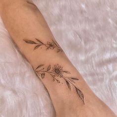 a woman's foot with a flower tattoo on the left side of her leg