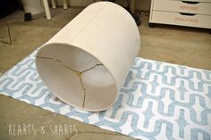 a white pipe laying on top of a blue and white rug in a room with drawers