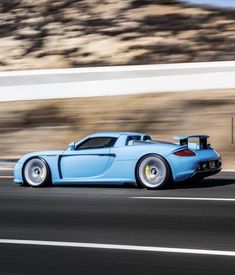 a blue sports car driving down the road