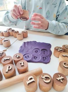 a child playing with wooden letters and numbers