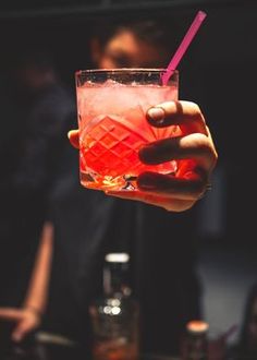 a person holding a drink in their hand