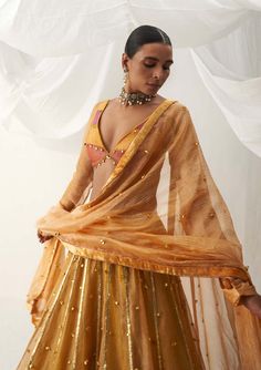 Editor's Note Elevate your style with our color-blocked choli-patterned blouse, featuring churi sleeves and a backless design, perfectly paired with a warm shade of mustard lehenga adorned with ghungroo sprinkling all over and gota stripes along the hem. This ensemble is completed with a tissue dupatta, making it an ideal choice for special occasions where you want to make a striking and fashionable statement with a touch of elegance and grace. Fabric: Lampi and tissue Color: Yellow Component: L Churi Sleeves, Mustard Lehenga, Choli Pattern, Tissue Dupatta, Indian Dress Up, Ghaghra Choli, Yellow Lehenga, Gaun Fashion