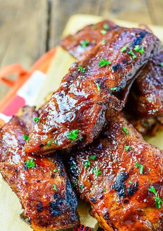 ribs covered in bbq sauce and garnished with parsley on a cutting board