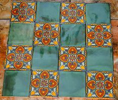 an artistic tile design on the floor in a room with orange and blue tiles,