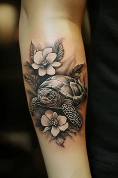 a woman's arm with a turtle and flowers on it